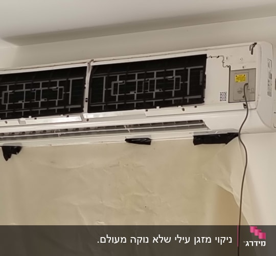 מזגן מפורק עם כיסוי פלסטיק פתוח על הקיר